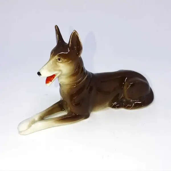 Foto de um(a) Antiga Pequena Escultura Bibelô Cachorro Pastor Em Porcelana, da categoria de Escultura. Antigo bibelô em porcelana alemã. Década de 1950. Medidas 9x14cm. Mostrado de uma perspectiva diferente. Vendido no marketplace Trésors.