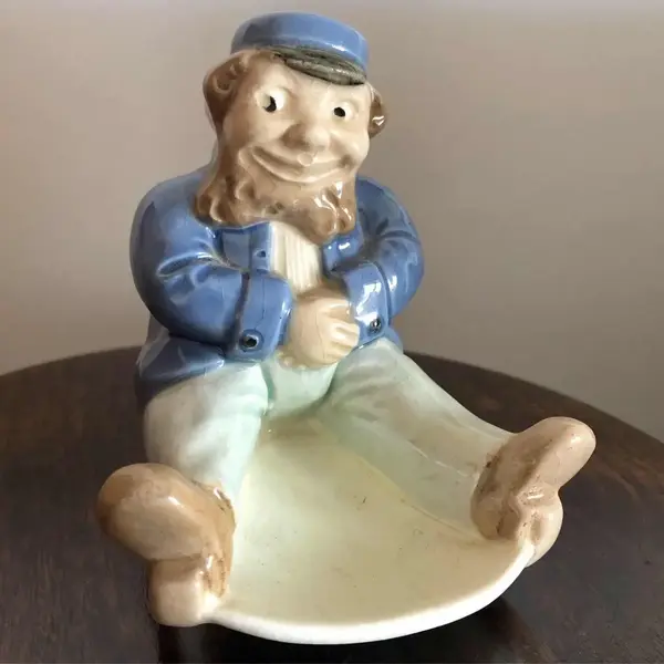 Foto de um(a) Antigo Bibelô De Coleção Art Deco Porcelana Alemã, da categoria de Escultura. Bibelô em porcelana alemã, representando senhor que balança na cadeira, período Art Deco. Década de 1940.Medidas 12x12xcm. Mostrado de uma perspectiva diferente. Vendido no marketplace Trésors.