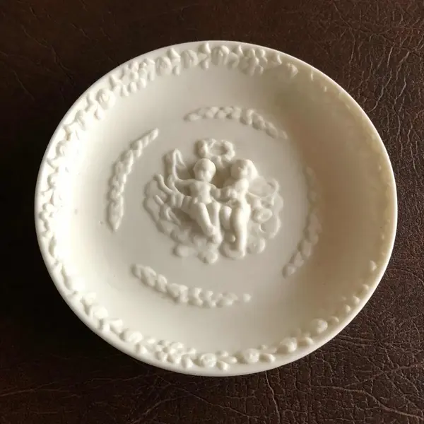 Foto de um(a) Antigo Pratinho De Parede Em Biscuit Francês, da categoria de Pratos Decorativos. Antigo pratinho de parede em biscuit francês ricamente decorado com querubins e flores. Em perfeito estado. Mede: 11cm. Mostrado de uma perspectiva diferente. Vendido no marketplace Trésors.