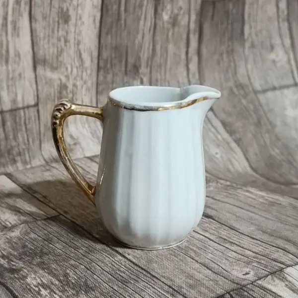 Foto de um(a) Cremeira Porcelana Branca Filetada a Ouro, Década de 1970, da categoria de Cremeiras. Cremeira em porcelana branca canelada com filete, alça e bico em ouro, década de 1970 sem marca do fabricante. A: 9cm L alça... Mostrado de uma perspectiva diferente. Vendido no marketplace Trésors.
