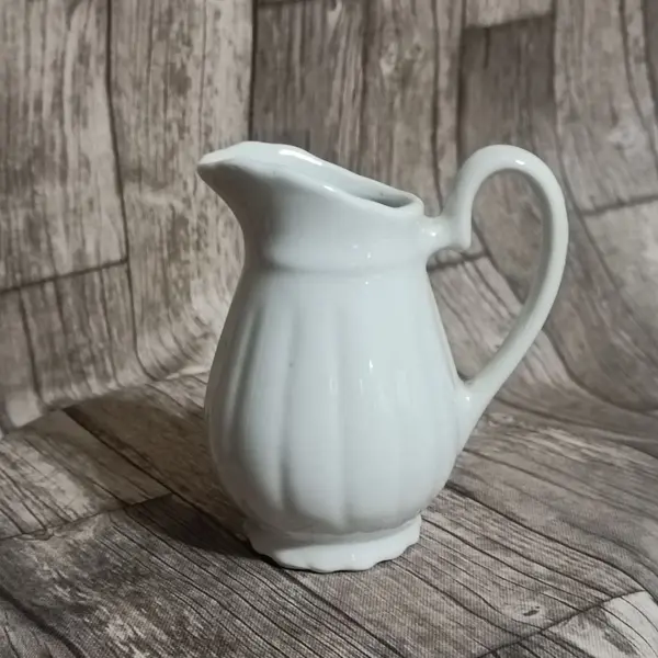 Foto de um(a) Cremeira Porcelana Branca, Década de 1980, da categoria de Cremeiras. Cremeira em porcelana branca canelada, década de 1980 sem marca do fabricante A: 12,5cm L alça até o bico: 11cm D: 7cm. Mostrado de uma perspectiva diferente. Vendido no marketplace Trésors.