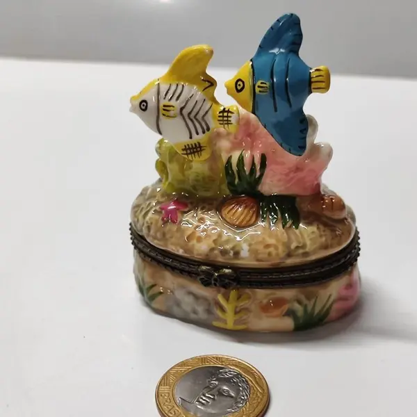 Foto de um(a) Porta Joias Caixinha Peixinhos em Porcelana, Década de 1990, da categoria de Porta-Jóias. Porta jóia peixinhos em porcelana policromada, fecho em latão oxidado. Made in china, década de 1990 A: 7,5 cm / L: 6 cm /... Mostrado de uma perspectiva diferente. Vendido no marketplace Trésors.