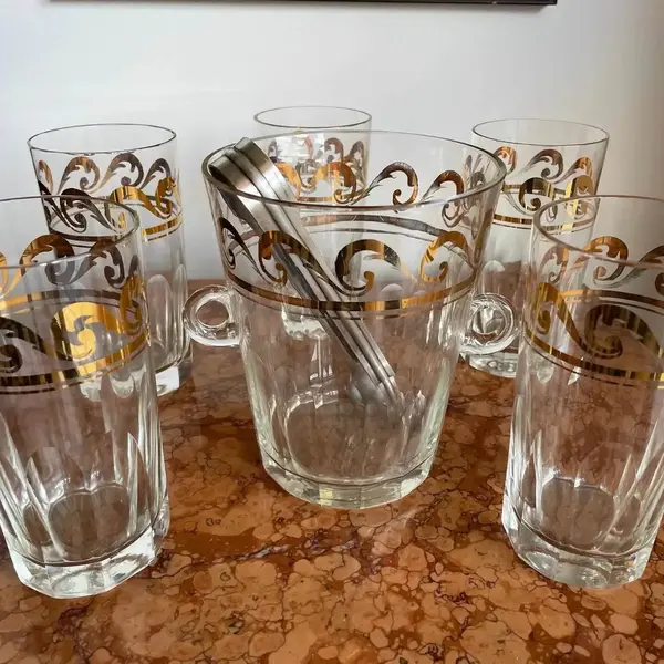 Foto de um(a) Antigo Conjunto Balde De Gelo Com Copos Cristal Art Deco, da categoria de Baldes de Gelo. Antigo e fino conjunto composto por balde gelo e 5 copos em cristal europeu lapidados à mão, com filetes de ouro, acompanha... Mostrado de uma perspectiva diferente. Vendido no marketplace Trésors.