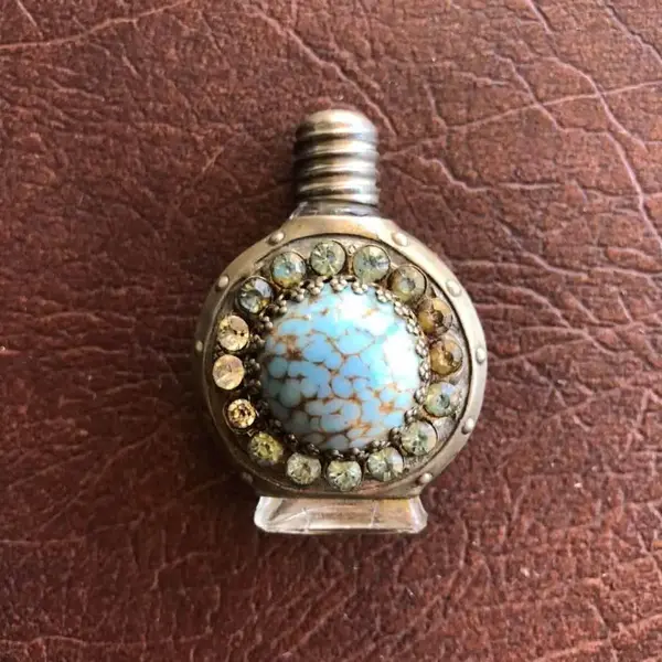 Foto de um(a) Antigo Pequeno Perfumeiro De Coleção Com Pedras, da categoria de Perfumeiros. Pequeno perfumeiro feito a mão. Usado antigamente para levar no bolso para viagens. Item de colecionador. Mede aprox 5cm. Mostrado de uma perspectiva diferente. Vendido no marketplace Trésors.