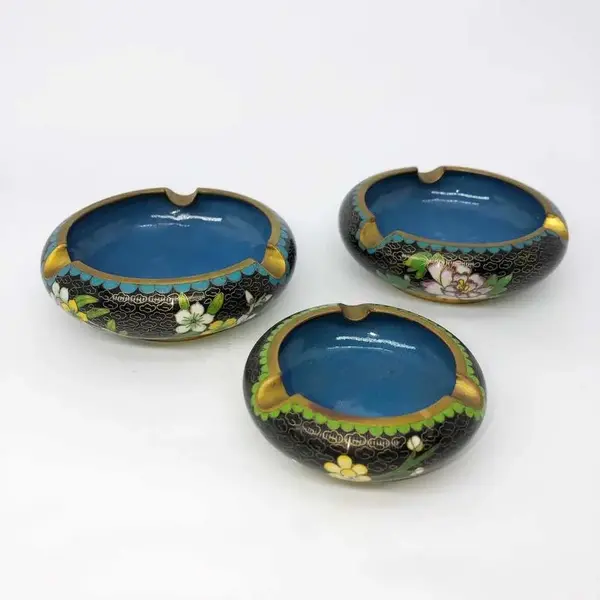 Foto de um(a) Antigo Trio De Cinzeiros Orientais Em Bronze Cloisonné, da categoria de Cinzeiros. Antigos e lindos cinzeiros orientais feitos à mão em Cloisonné. Decorados com flores e folhagens, com esmalte azul na parte... Mostrado de uma perspectiva diferente. Vendido no marketplace Trésors.