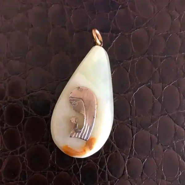 Foto de um(a) Arte Sacra Antigo Pingente Dourado De Santa Em Pedra Ônix, da categoria de Objetos religiosos e espirituais. Peça muito delicada, de meados do século XX. Medida 4cm. Mostrado de uma perspectiva diferente. Vendido no marketplace Trésors.