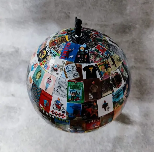 Foto de um(a) Globo Tintim, Herge, da categoria de Globos. Globo tintim globo com esfera giratória de plástico decoupado com imagens do tintim, estrutura em ferro com detalhes em... Mostrado de uma perspectiva diferente. Vendido no marketplace Trésors.