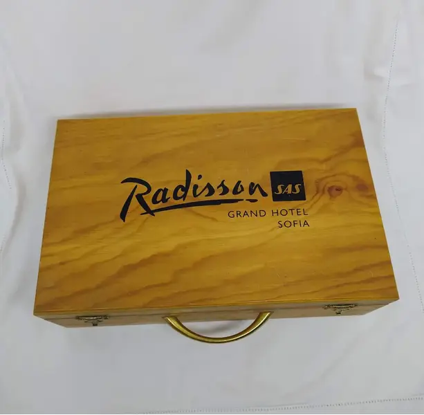 Foto de um(a) Caixa Hotel Radisson antiga em madeira, da categoria de Cestos e Caixas. Caixa de madeira antiga, da rede de hotéis Radisson. Possui divisórias internas para uma garrafa pequena, compartimento para... Mostrado de uma perspectiva diferente. Vendido no marketplace Trésors.