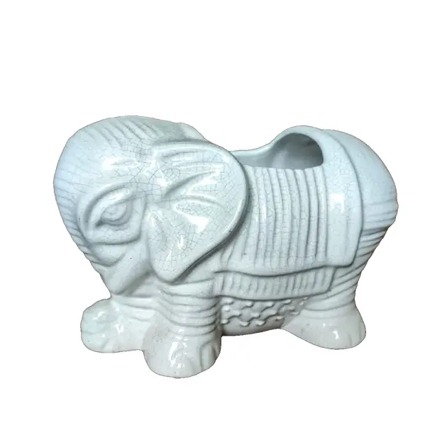 Foto de um(a) Cachepô Elefante Anos 90, da categoria de Cachepot. Cachepô formato de elefante em porcelana craquelada na cor branca, década de 1990. A: 12,5 cm / L: 20cm / P: 12 cmPeso: 704g. Vendido no marketplace Trésors.