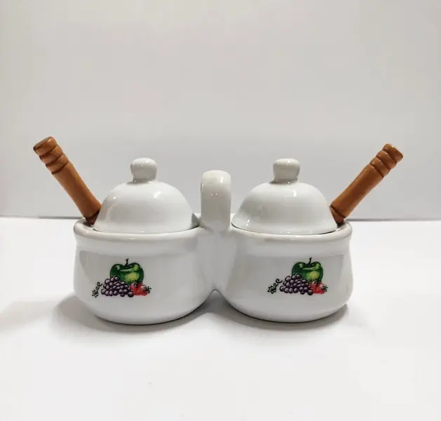 Foto de um(a) Galheteiro de Mesa em Porcelana, Década de 2000, da categoria de Saleiros e pimenteiros. Galheteiro de mesa em porcelana com adesivo de frutas somente de um lado. Tampa e colheres com cabo de madeira. Made in... Mostrado de uma perspectiva diferente. Vendido no marketplace Trésors.