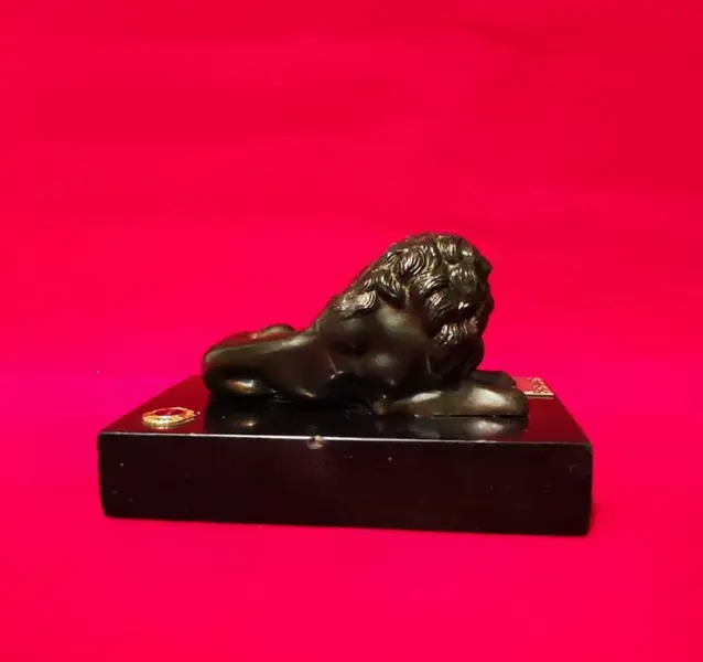 Foto de um(a) Troféu Leão do Ano, 71/72, da categoria de Escultura. Troféu Lions 1971/1972 - Leão do Ano. Em bronze com base de granito preto. A: 7 cm / L: 12 cm / P: 7,4 cm peso: 738 g. Mostrado de uma perspectiva diferente. Vendido no marketplace Trésors.