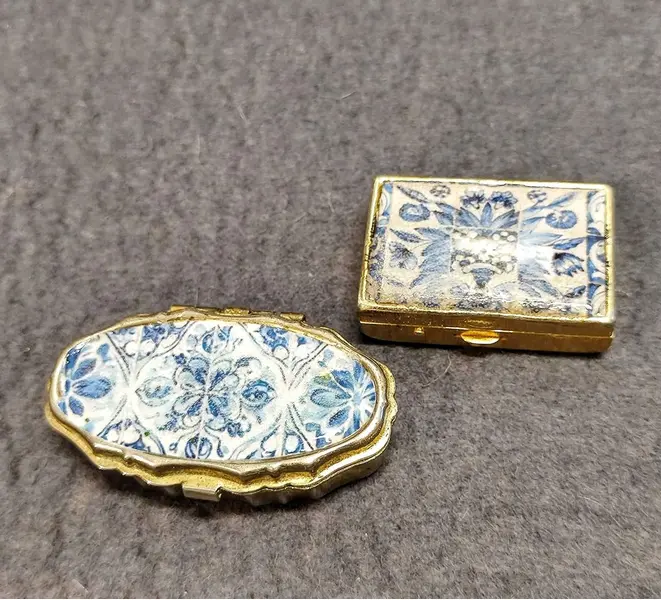 Foto de um(a) Combo Caixinhas de Metal Azulejo Português, da categoria de Cestos e Caixas. Combo de duas caixas de metal com estampa de azulejos portugueses: uma porta comprimidos e outra caixa de costura, década de... Mostrado de uma perspectiva diferente. Vendido no marketplace Trésors.