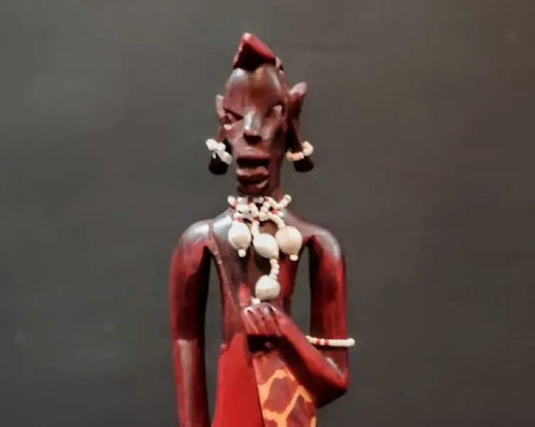 Foto de um(a) Escultura Africana Anos 80, da categoria de Escultura. Escultua africana em madeira policromada com missangas e sementes, década de 1980. A: 30 cm / L: 6,5 cm / P: 4 cm Peso: 248 g. Mostrado de uma perspectiva diferente. Vendido no marketplace Trésors.