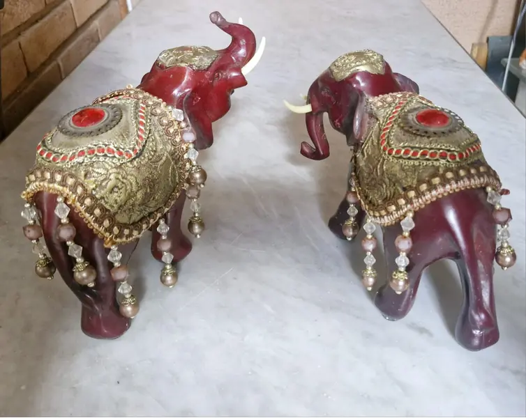 Foto de um(a) Par de Elefantes Antigos Feng Shui, da categoria de Modelos e estatuetas. Par de elefantes em tom de vinho com mantos dourados e pedrarias, que representam a Realeza e a Abundância. Os Mantos:... Mostrado de uma perspectiva diferente. Vendido no marketplace Trésors.