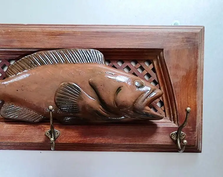 Foto de um(a) Cabideiro Fish em Cerejeira e Cerâmica, da categoria de Cabideiros e porta-chapéus. Cabideiro com peixe em cerâmica. Moldura em cerejeira maciça e fundo em treliça fazendo um link com a rede, três ganchos com... Mostrado de uma perspectiva diferente. Vendido no marketplace Trésors.