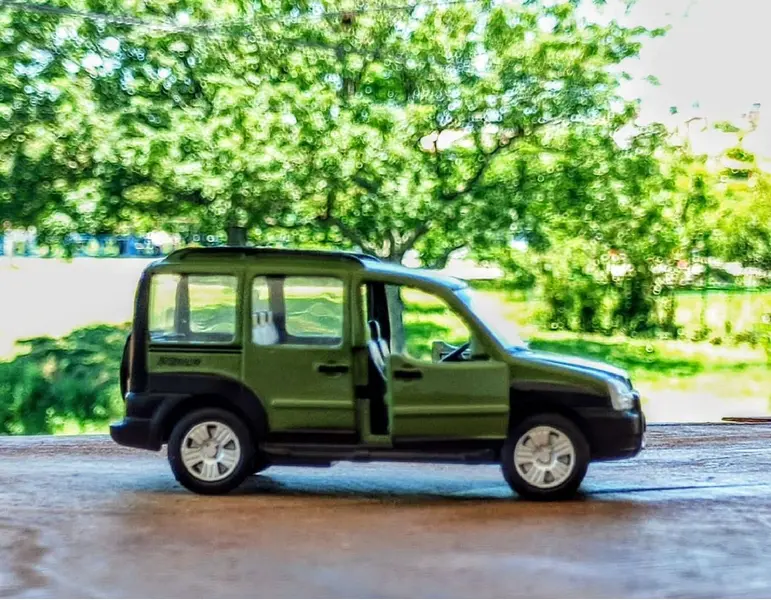 Foto de um(a) Mini Fiat Doblo, Escala 1/43, da categoria de Modelos de carros. Miniatura do fiat doblo adventure em metal com detalhes internos em plástico, pneus de borracha, fricção e portas da frente... Mostrado de uma perspectiva diferente. Vendido no marketplace Trésors.