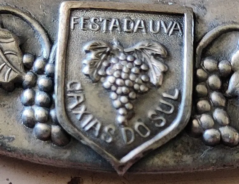Foto de um(a) Prato Comemorativo da Festa da Uva de Caxias do Sul, Década de 1960, da categoria de Pratos Decorativos. Prato comemorativo da festa da uva de caxias do sul dos anos 1960, em latão com desenho e borda em relevo, espessurado em... Mostrado de uma perspectiva diferente. Vendido no marketplace Trésors.