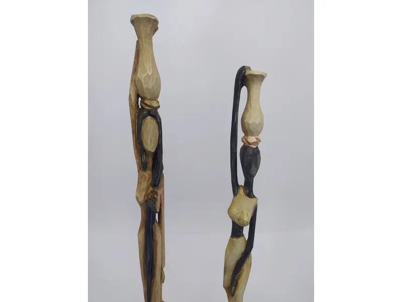 Foto de um(a) Par de esculturas africanas em madeira, da categoria de Escultura. Par de esculturas africanas em madeira, pintada à mão, retratando mulheres carregando baldes. Mede A: 31cm. Mostrado de uma perspectiva diferente. Vendido no marketplace Trésors.