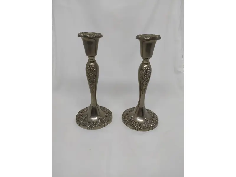 Foto de um(a) Par de castiçais em estanho, da categoria de Castiçais. Belíssimo par de castiçais em estanho, com motivos florais. MEDINDO 21x9,5cm (AxD) PESO/cada: 560g. Mostrado de uma perspectiva diferente. Vendido no marketplace Trésors.