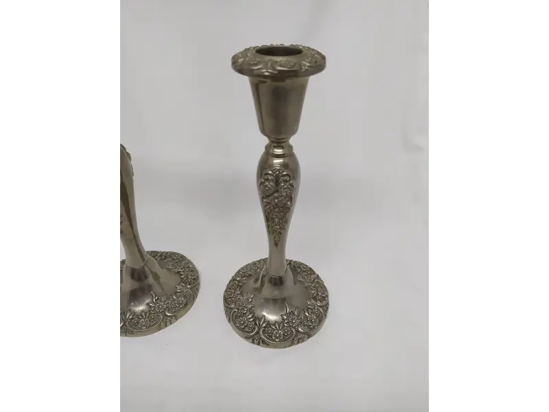 Foto de um(a) Par de castiçais em estanho, da categoria de Castiçais. Belíssimo par de castiçais em estanho, com motivos florais. MEDINDO 21x9,5cm (AxD) PESO/cada: 560g. Mostrado de uma perspectiva diferente. Vendido no marketplace Trésors.