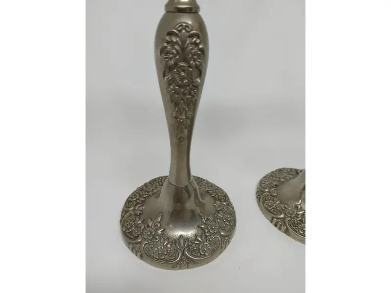 Foto de um(a) Par de castiçais em estanho, da categoria de Castiçais. Belíssimo par de castiçais em estanho, com motivos florais. MEDINDO 21x9,5cm (AxD) PESO/cada: 560g. Mostrado de uma perspectiva diferente. Vendido no marketplace Trésors.