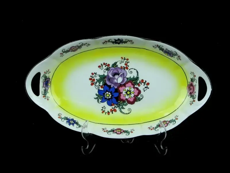Foto de um(a) Travessa formato navete em porcelana branca com decoração floral, da categoria de Travessas e tigelas. Original travessa com forma de navete em porcelana branca com decoração floral em policromia. Apresenta pegas vazadas nas... Mostrado de uma perspectiva diferente. Vendido no marketplace Trésors.