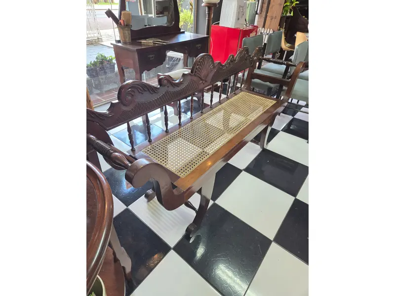 Foto de um(a) Namoradeira em imbuia maciça entalhada com assento em palhinha, da categoria de Recamier e Chaise. Banco antigo confeccionado em imbuia maciça entalhada à mão, apresentando rico trabalho artesanal no encosto e nos braços... Mostrado de uma perspectiva diferente. Vendido no marketplace Trésors.