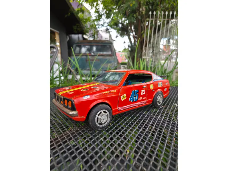 Foto de um(a) Carro Brinquedo Mitsubishi Galant GTO 1970 – Miniatura Clássica de Época, da categoria de Carros e caminhões de brinquedo. Carro brinquedo lendário Mitsubishi Galant GTO 1970, ícone esportivo japonês dos anos 70. Peça vintage, linhas marcantes e... Mostrado de uma perspectiva diferente. Vendido no marketplace Trésors.