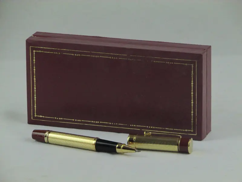 Foto de um(a) Par de canetas LUCKY, da categoria de Outros objetos decorativos. Par de canetas no estojo original da marca LUCKY. Em fino acabamento dourado com detalhes em bordô, uma dela sendo tinteiro.... Mostrado de uma perspectiva diferente. Vendido no marketplace Trésors.