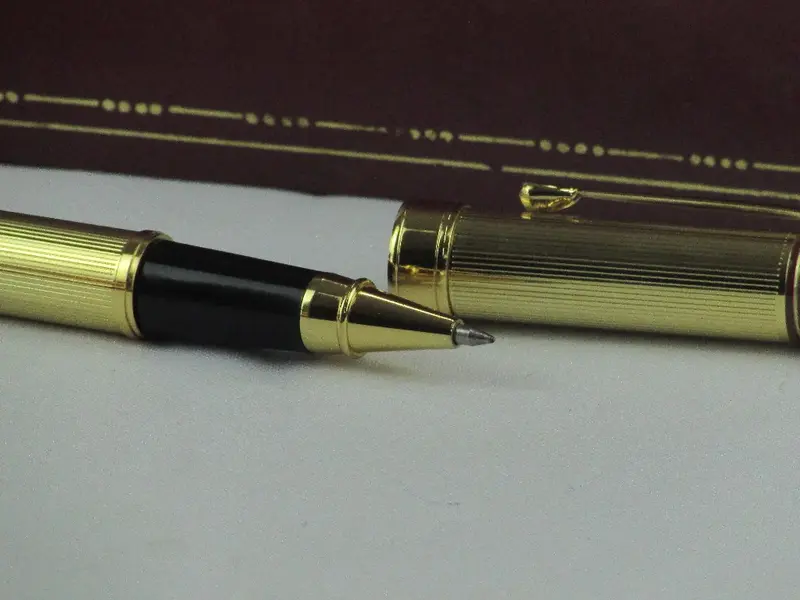 Foto de um(a) Par de canetas LUCKY, da categoria de Outros objetos decorativos. Par de canetas no estojo original da marca LUCKY. Em fino acabamento dourado com detalhes em bordô, uma dela sendo tinteiro.... Mostrado de uma perspectiva diferente. Vendido no marketplace Trésors.