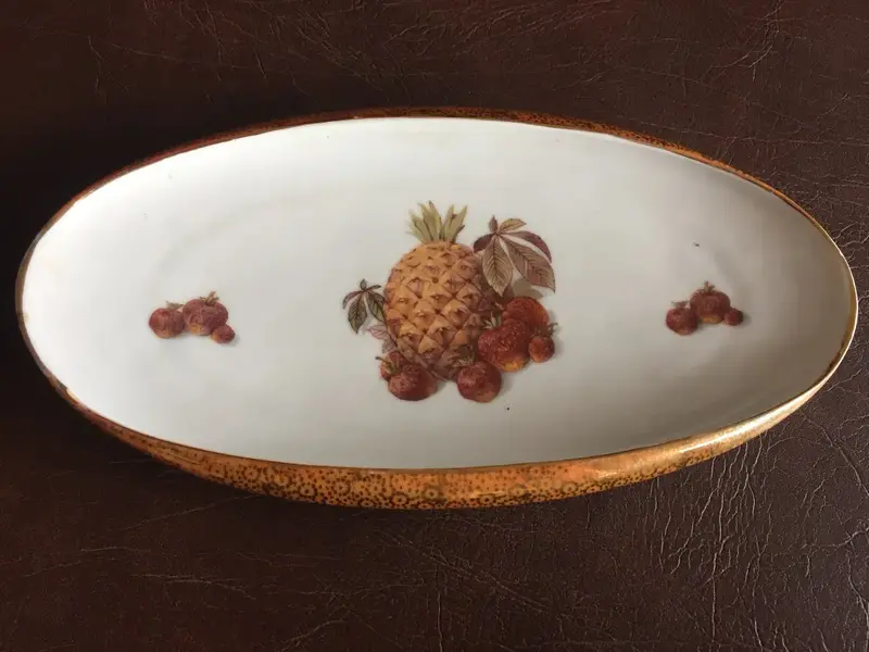 Foto de um(a) Antigo Centro De Mesa Prato Em Porcelana Real Com Frutas, da categoria de Travessas e tigelas. Porcelana antiga, borda dourada trabalhada com ouro. Em perfeito estado. Altura: 4cmComprimento: 27cmProfundidade: 15cm. Mostrado de uma perspectiva diferente. Vendido no marketplace Trésors.
