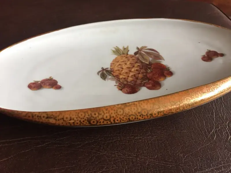Foto de um(a) Antigo Centro De Mesa Prato Em Porcelana Real Com Frutas, da categoria de Travessas e tigelas. Porcelana antiga, borda dourada trabalhada com ouro. Em perfeito estado. Altura: 4cmComprimento: 27cmProfundidade: 15cm. Mostrado de uma perspectiva diferente. Vendido no marketplace Trésors.