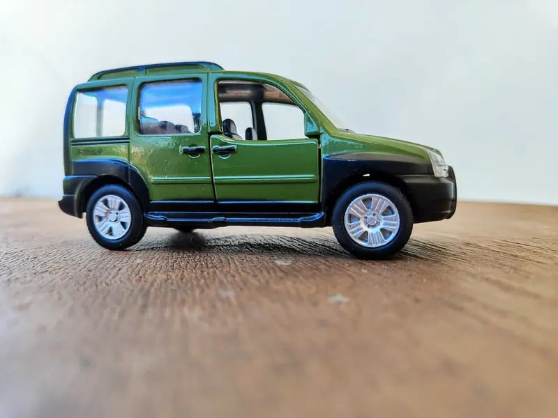 Foto de um(a) Mini Fiat Doblo, Escala 1/43, da categoria de Modelos de carros. Miniatura do fiat doblo adventure em metal com detalhes internos em plástico, pneus de borracha, fricção e portas da frente... Mostrado de uma perspectiva diferente. Vendido no marketplace Trésors.