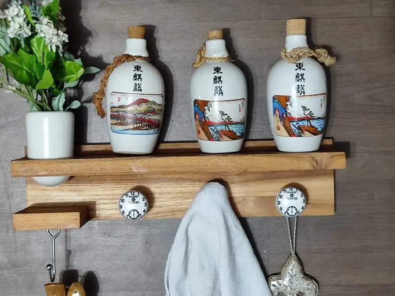 Foto de um(a) Cabideiro em Madeira e Detalhes em Porcelana, da categoria de Cabideiros e porta-chapéus. Cabideiro de parede em madeira natural com ganchos em porcelana e um em metal que é móvel. Com prateleira e suporte para um... Mostrado de uma perspectiva diferente. Vendido no marketplace Trésors.