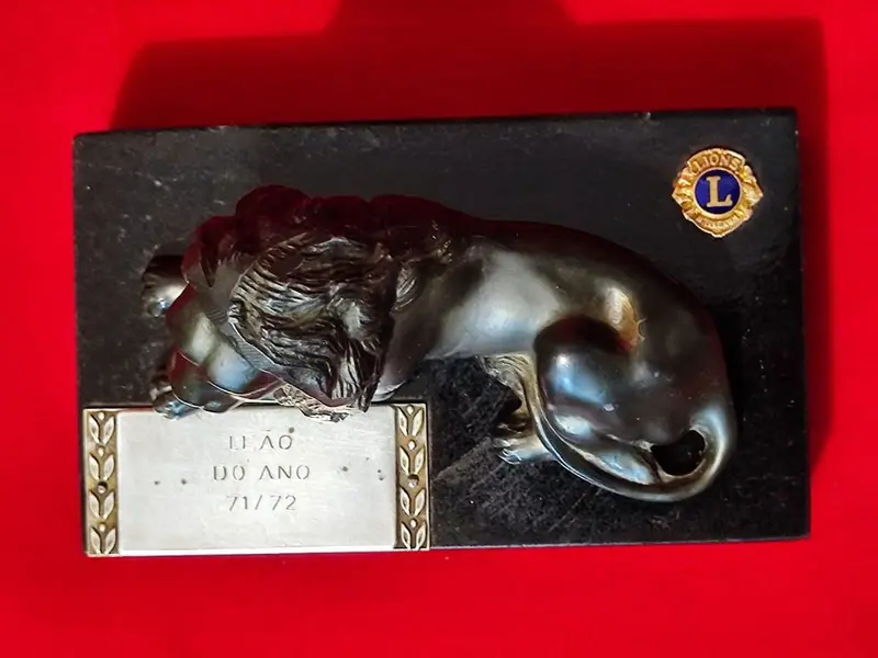 Foto de um(a) Troféu Leão do Ano, 71/72, da categoria de Escultura. Troféu Lions 1971/1972 - Leão do Ano. Em bronze com base de granito preto. A: 7 cm / L: 12 cm / P: 7,4 cm peso: 738 g. Mostrado de uma perspectiva diferente. Vendido no marketplace Trésors.