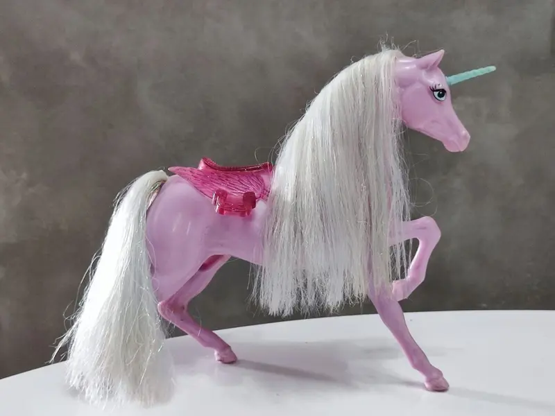 Foto de um(a) Unicórnio Barbie, Mattel, da categoria de Bonecas. Unicórnio lilás - barbie lago dos cisnes. Fabricante: mattel inc méxico 1983. A 27 cm / L 24,5 / P 7,5 cm / Peso: 380 g. Mostrado de uma perspectiva diferente. Vendido no marketplace Trésors.