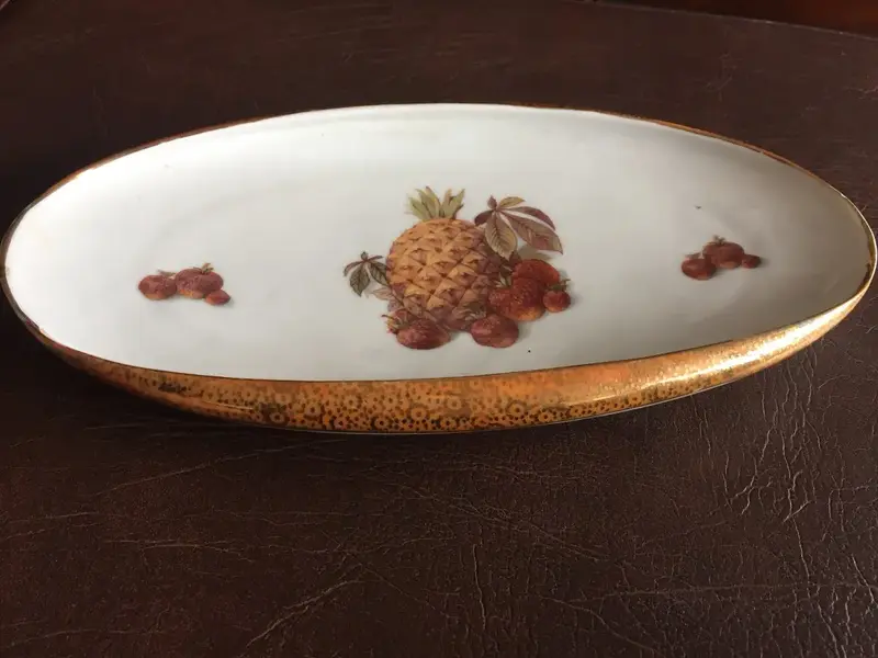 Foto de um(a) Antigo Centro De Mesa Prato Em Porcelana Real Com Frutas, da categoria de Travessas e tigelas. Porcelana antiga, borda dourada trabalhada com ouro. Em perfeito estado. Altura: 4cmComprimento: 27cmProfundidade: 15cm. Mostrado de uma perspectiva diferente. Vendido no marketplace Trésors.