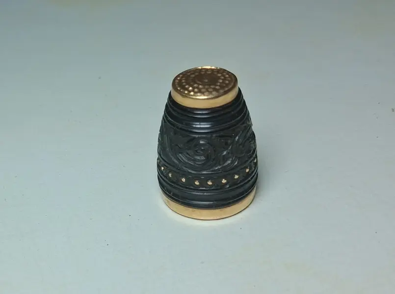 Foto de um(a) Joia de Crioula - dedal em coco e ouro séc. XIX, da categoria de Outros colecionáveis. Raro exemplar de jóia de crioula, dedal em coco trabalhado e borda e base em ouro. Línda peça. 2 x 1 cm. Mostrado de uma perspectiva diferente. Vendido no marketplace Trésors.