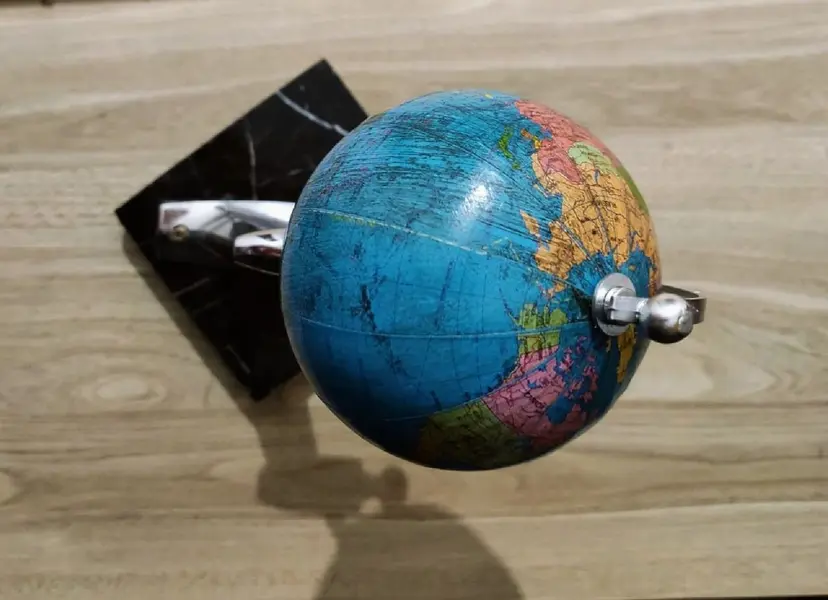 Foto de um(a) Globo Corcel 69, da categoria de Globos. Globo terrestre de mesa com pegada vintage, haste de um retrovisor cromado de um corcel 1969 e base em granito preto peça... Mostrado de uma perspectiva diferente. Vendido no marketplace Trésors.