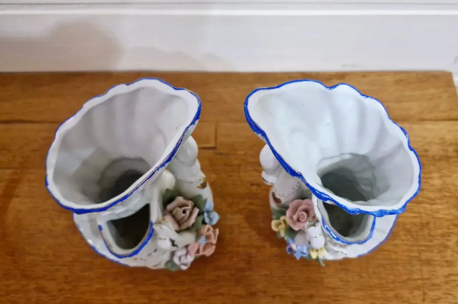 Foto de um(a) Excepcional par de floreiras em porcelana, da categoria de Vasos. Encantador par de vasos vintage confeccionado em porcelana branca com um design ornamental clássico no formato de cisnes... Mostrado de uma perspectiva diferente. Vendido no marketplace Trésors.
