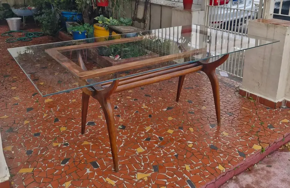 Foto de um(a) Mesa de jantar anos 50-60 com tampo de vidro, da categoria de Mesas de Jantar. Linda mesa de jantar feita na década de 1950/1960. Possui o design modernista, com suas linhas curvas, base em estrutura de... Mostrado de uma perspectiva diferente. Vendido no marketplace Trésors.