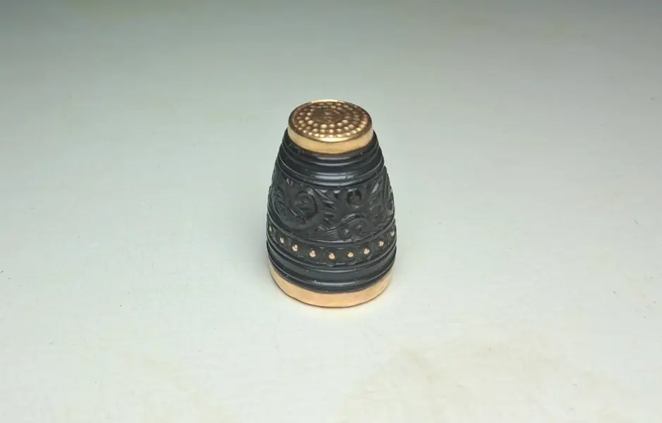 Foto de um(a) Joia de Crioula - dedal em coco e ouro séc. XIX, da categoria de Outros colecionáveis. Raro exemplar de jóia de crioula, dedal em coco trabalhado e borda e base em ouro. Línda peça. 2 x 1 cm. Mostrado de uma perspectiva diferente. Vendido no marketplace Trésors.