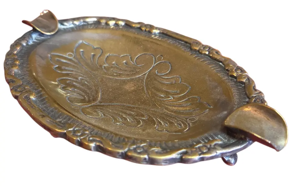 Foto de um(a) Cinzeiro Ornamentado em Metal, da categoria de Cinzeiros. Uma peça que exala sofisticação e história. Este cinzeiro oval em metal apresenta um rico trabalho de ornamentação, com... Mostrado de uma perspectiva diferente. Vendido no marketplace Trésors.