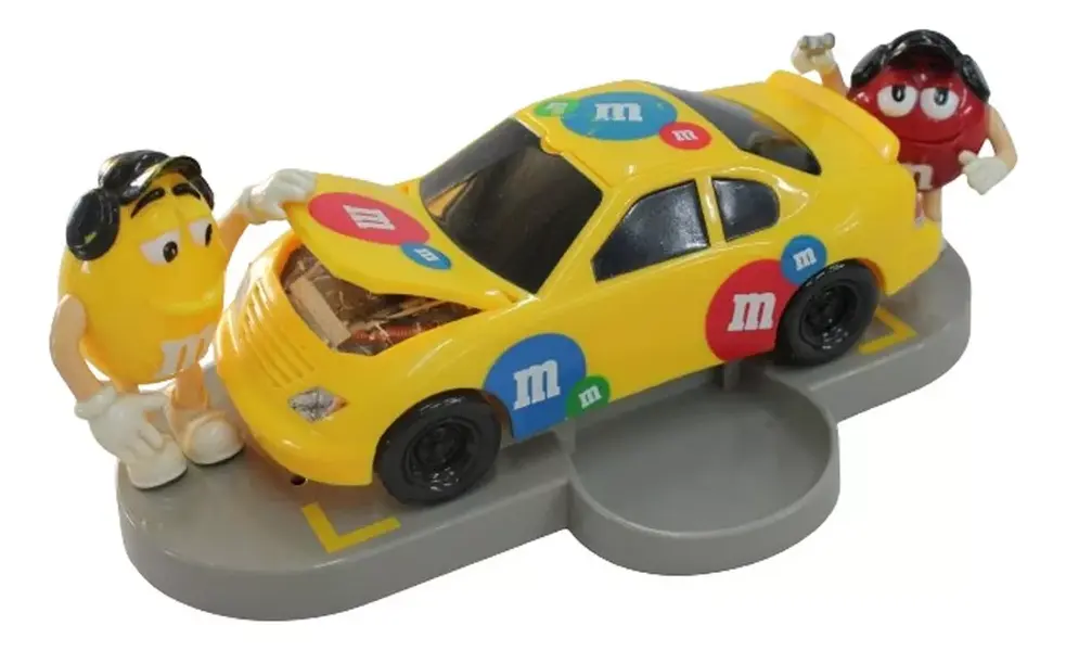 Foto de um(a) Dispenser M & M carro de corrida, da categoria de Brinquedos e Hobbies. Dispenser M&M em formato de carro com dois bonecos em cada lateral, abertura do dispenser fica no teto. Medidas carro 9A x... Mostrado de uma perspectiva diferente. Vendido no marketplace Trésors.